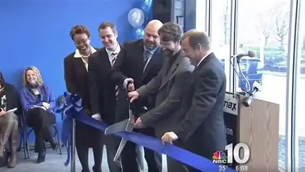 NBC10 news still of Ken Wisnefski and others cutting a blue ribbon at a WebiMax office opening
